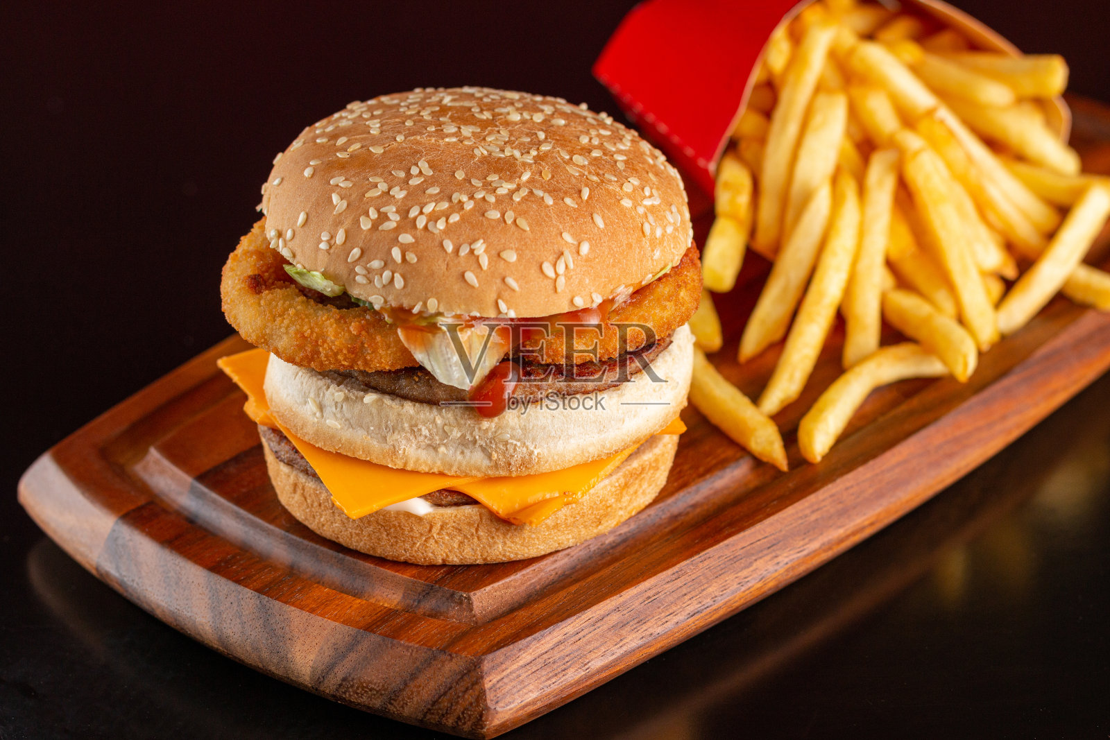 美味的汉堡洋葱圈,切达干酪,还有薯条。照片摄影图片