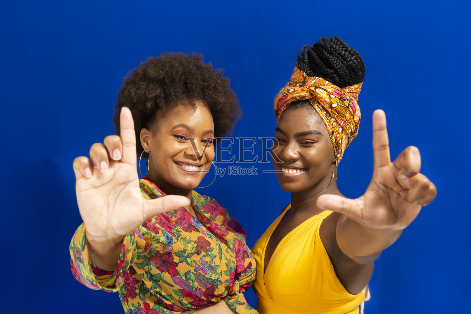 两个女人的肖像对蓝色背景。照片摄影图片