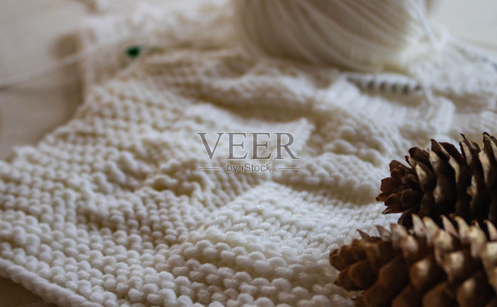 白色针织羊毛纹理特写,白色羊毛球背景,前景松果,冬季概念照片摄影图片