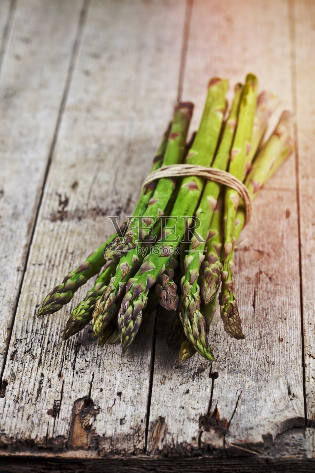 一束新鲜的生花园芦笋在质朴的木桌背景上。春天的青菜。照片摄影图片