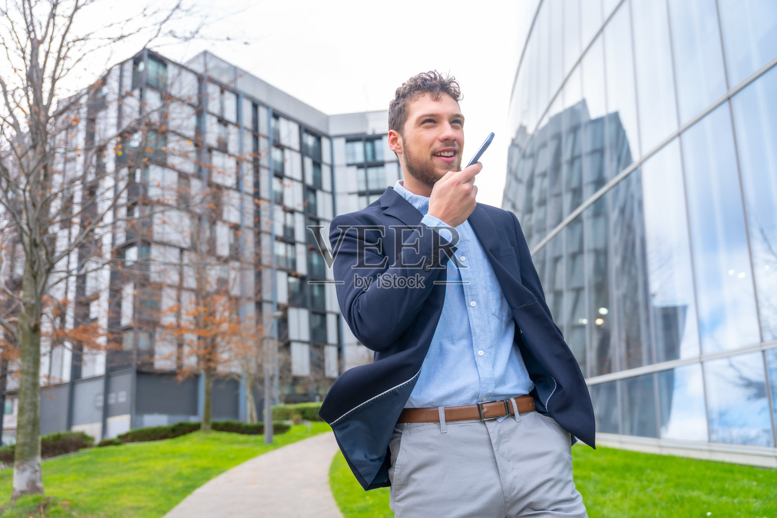 商人或金融人员用办公室外的电话发送语音通知,商业园区照片摄影图片