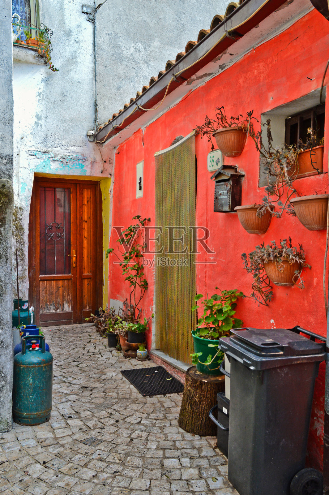 垂直拍摄的前门入口与一堵红墙在Ailano,在卡塞塔,意大利的一个村庄照片摄影图片