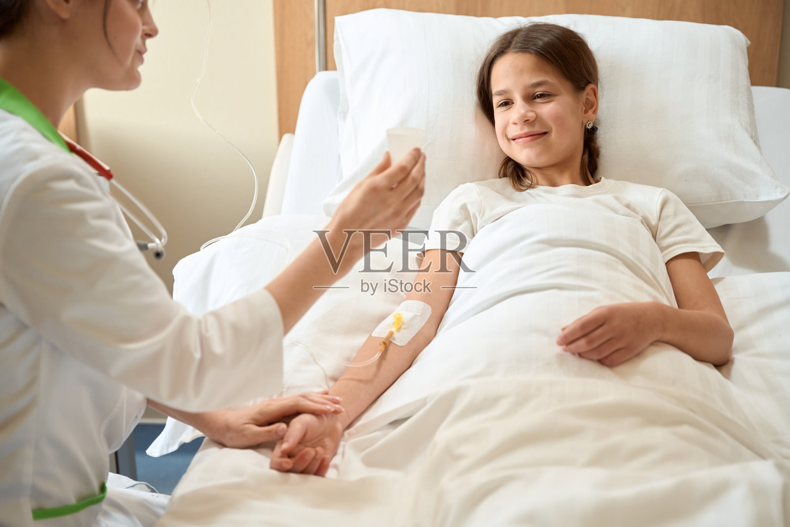 医生给女孩看了一个小医疗容器照片摄影图片