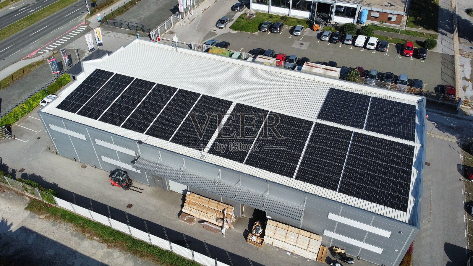 阳光明媚的日子里,装有太阳能电池板的建筑屋顶鸟瞰图照片摄影图片