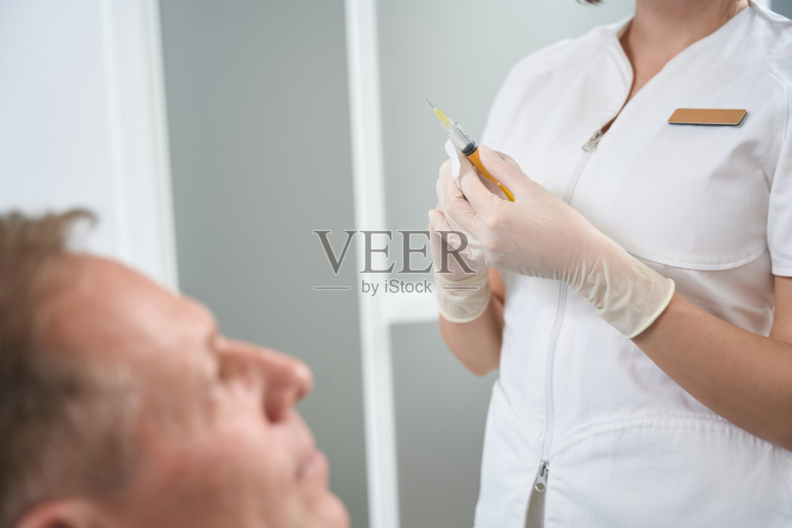 女医务人员拿着注射器站在病人旁边照片摄影图片