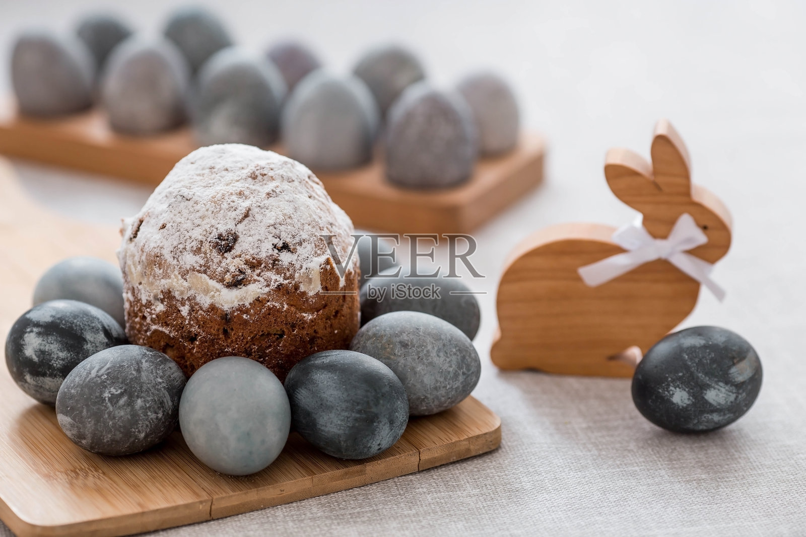 大理石和混凝土装饰的时尚灰色复活节彩蛋和木架上的蛋糕。用天然染料karkade茶给鸡蛋上色。环境友好。自然。2023年复活节快乐的概念。照片摄影图片