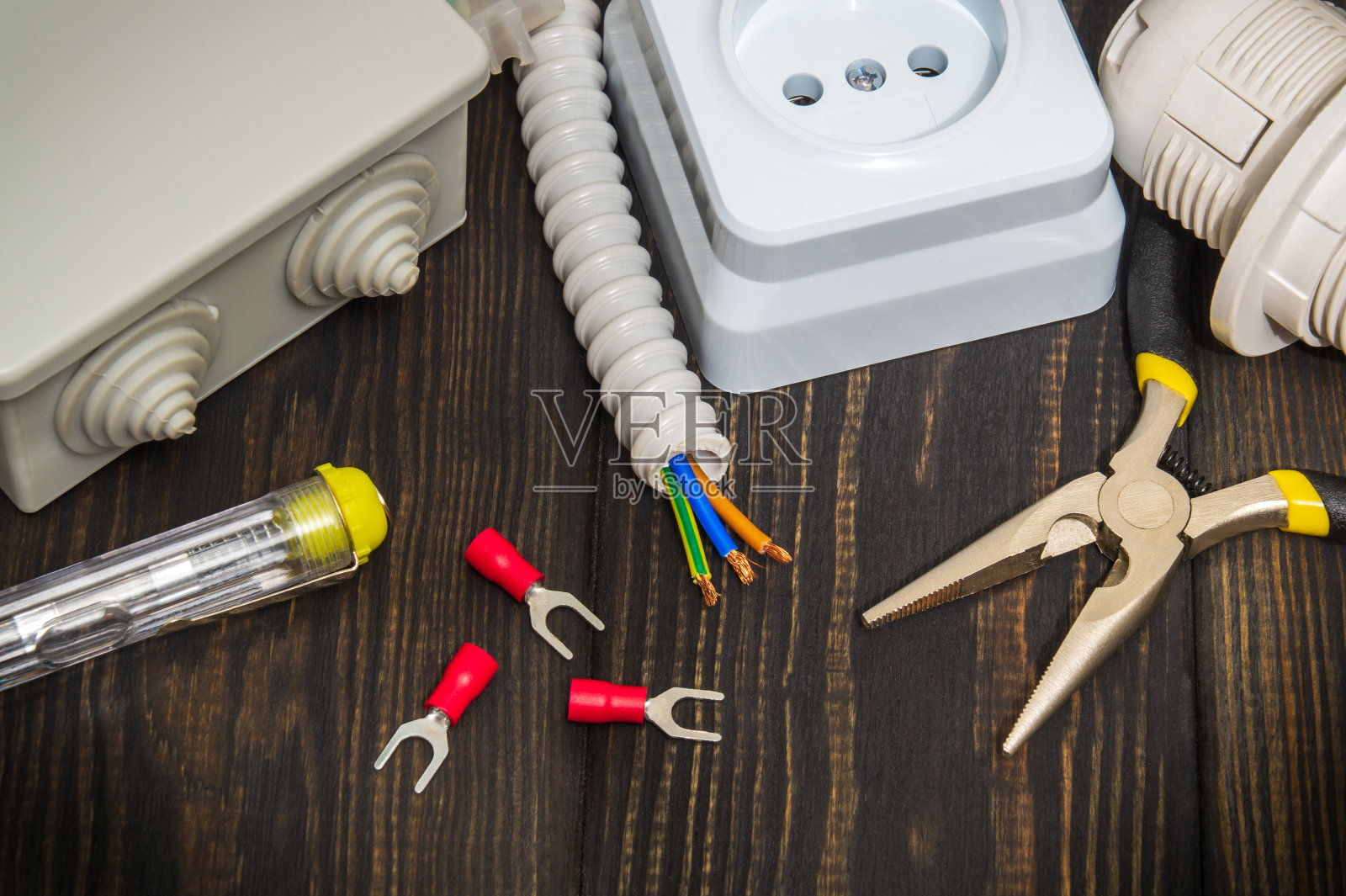 将电气维修备件安装在黑色木板上。在黑色木板上装配电气维修备件和工具。电工师傅的工作地点电工师傅的工作地点照片摄影图片