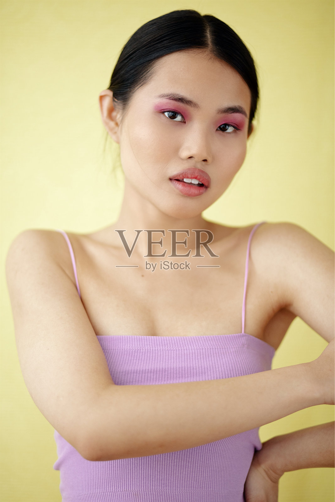 美丽的亚洲女人与彩色化妆品在工作室摆姿势。照片摄影图片