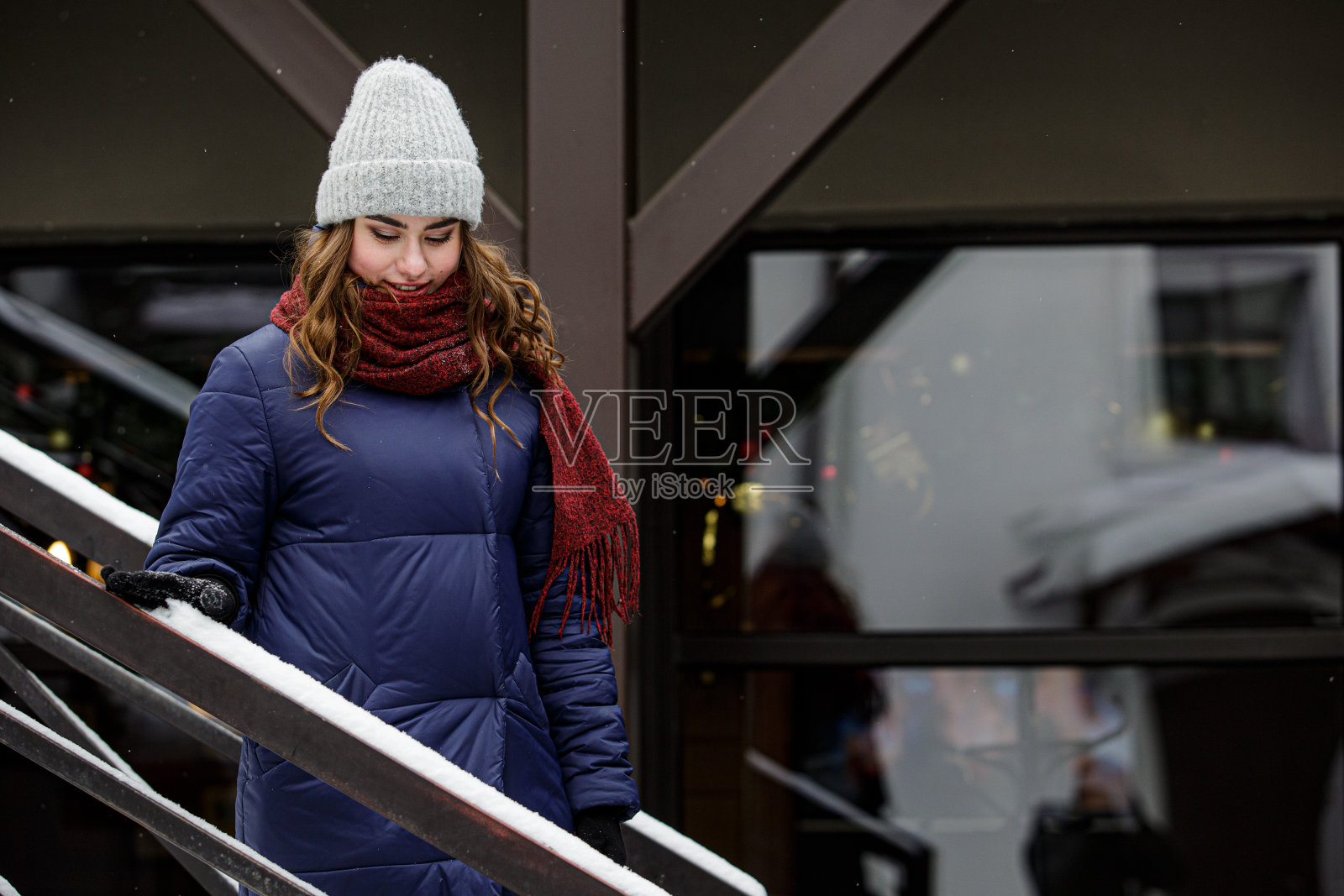 年轻快乐的女人享受冬天的天气戴着围巾和针织帽。照片摄影图片
