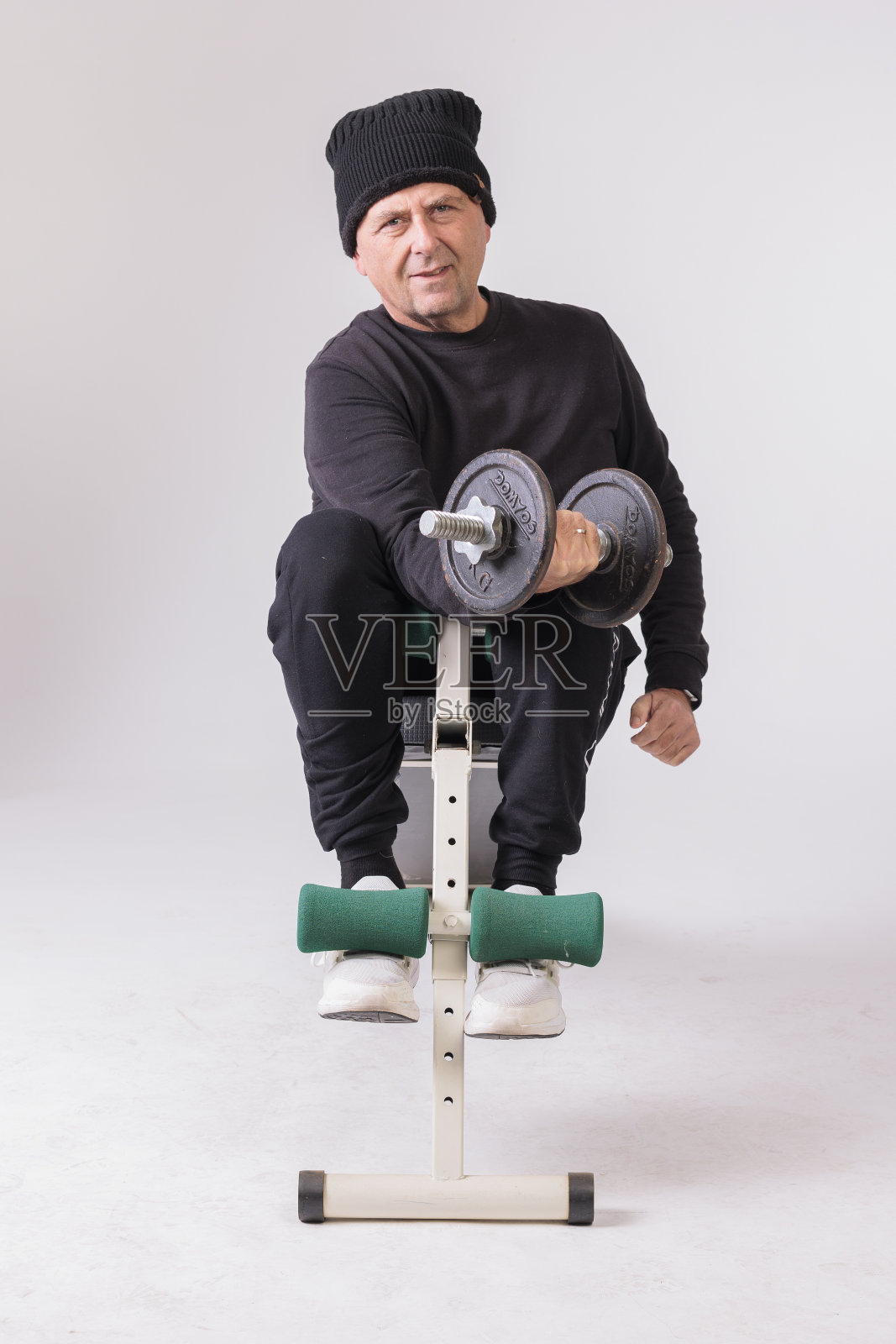 50多岁的男人在白色背景上做仰卧起坐照片摄影图片