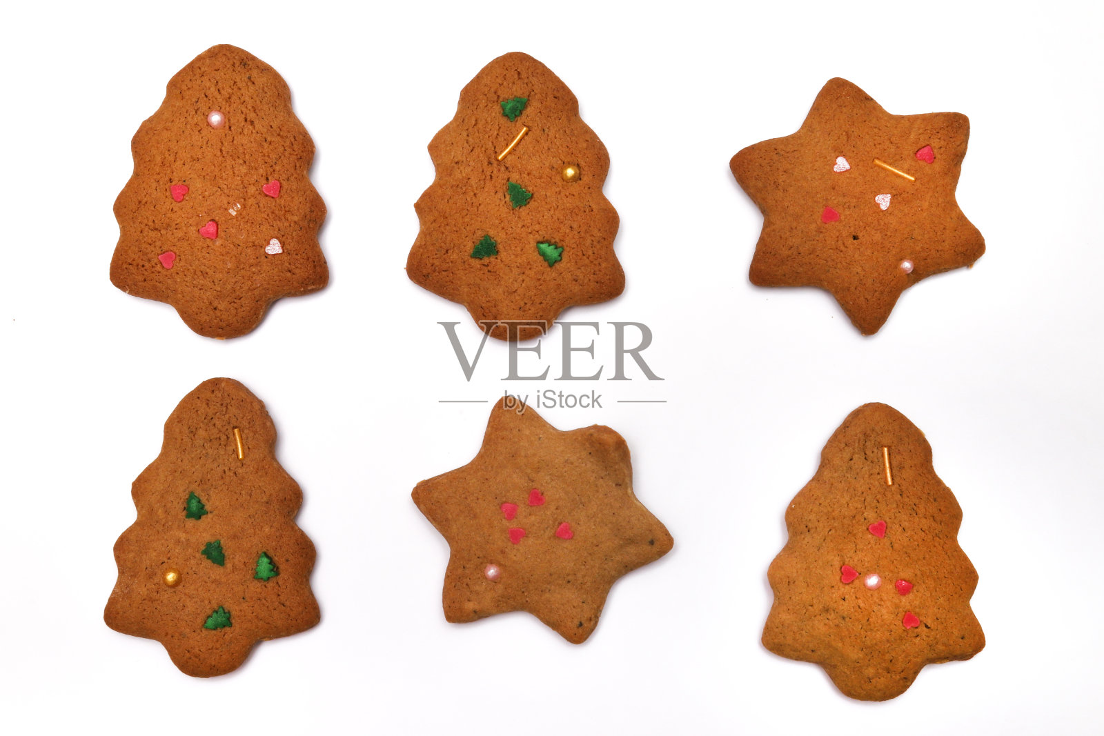 自制的饼干,白色背景上有一棵圣诞树和一颗星星。特写镜头照片摄影图片