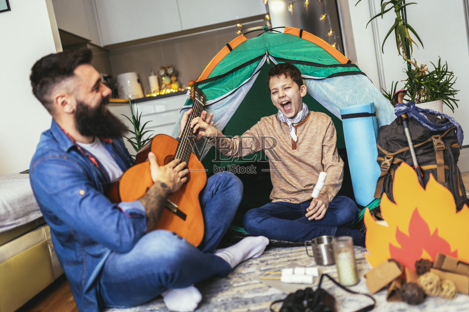 父亲和儿子在家里露营。照片摄影图片