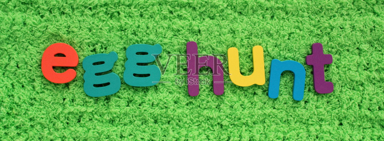 彩蛋狩猎彩色字母在绿色的草地背景。假日春天构图概念照片摄影图片