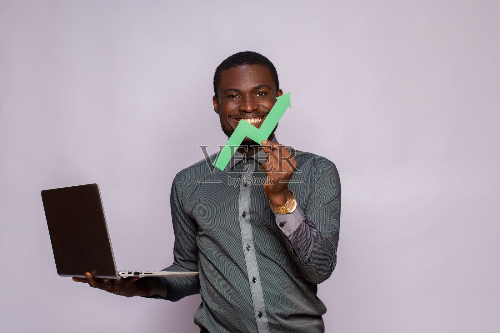 一个黑人拿着笔记本电脑和一个向上的图形符号,标志着进步照片摄影图片