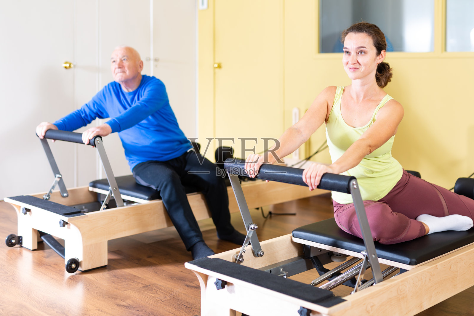 积极的妇女练习普拉提伸展练习在改革者照片摄影图片