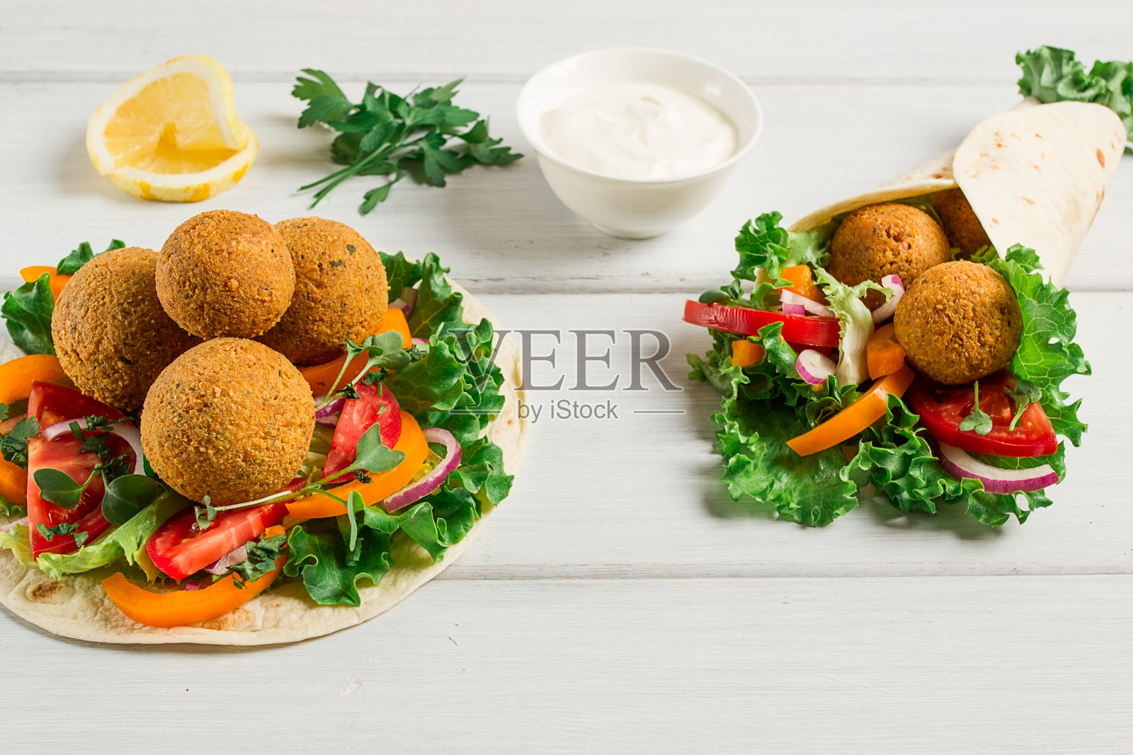 玉米饼,包着沙拉丸子,配上新鲜蔬菜,素食健康食品,以木质白色为背景,没有人,选择性聚焦。照片摄影图片