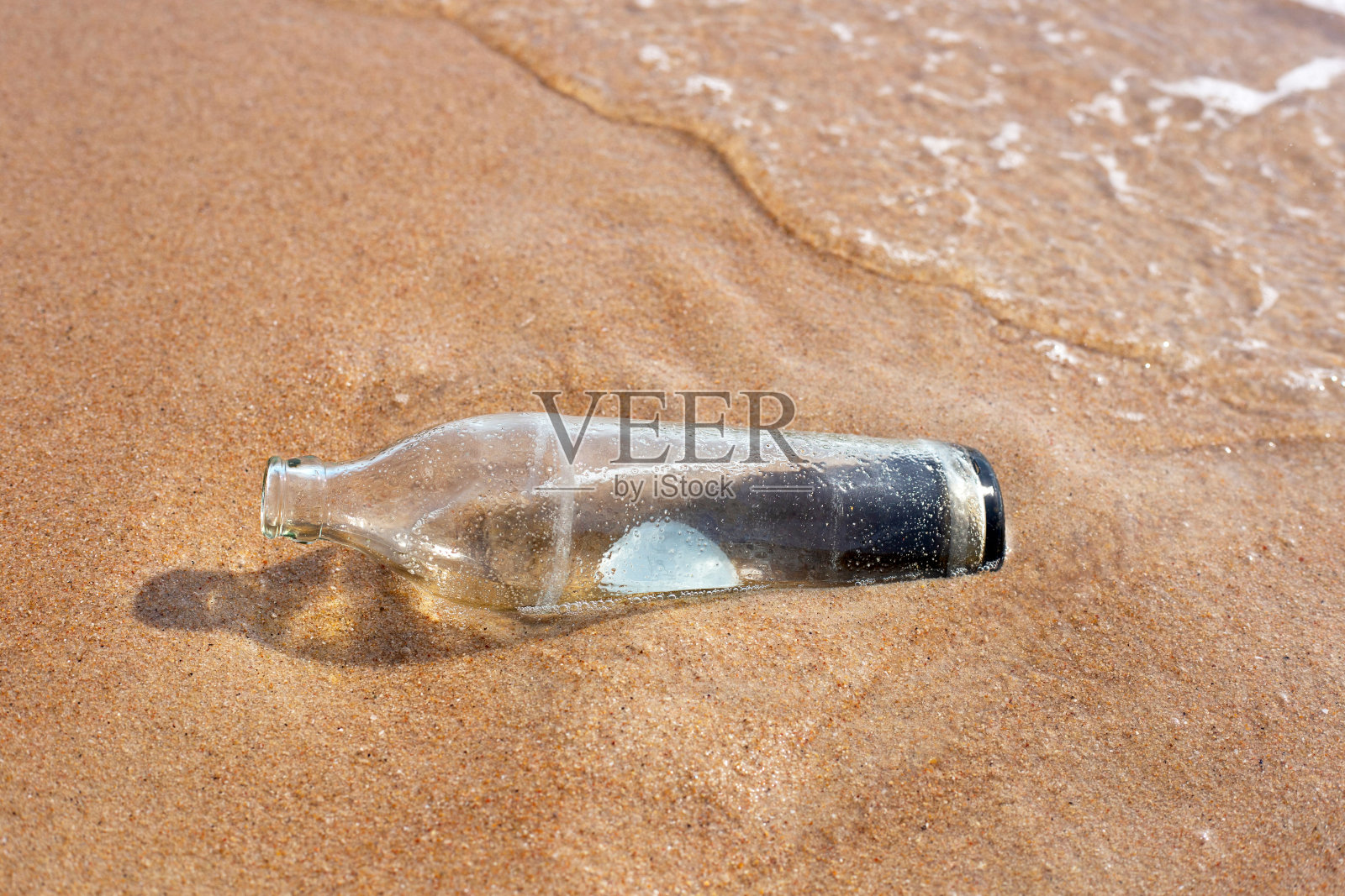 沙滩上的玻璃瓶照片摄影图片