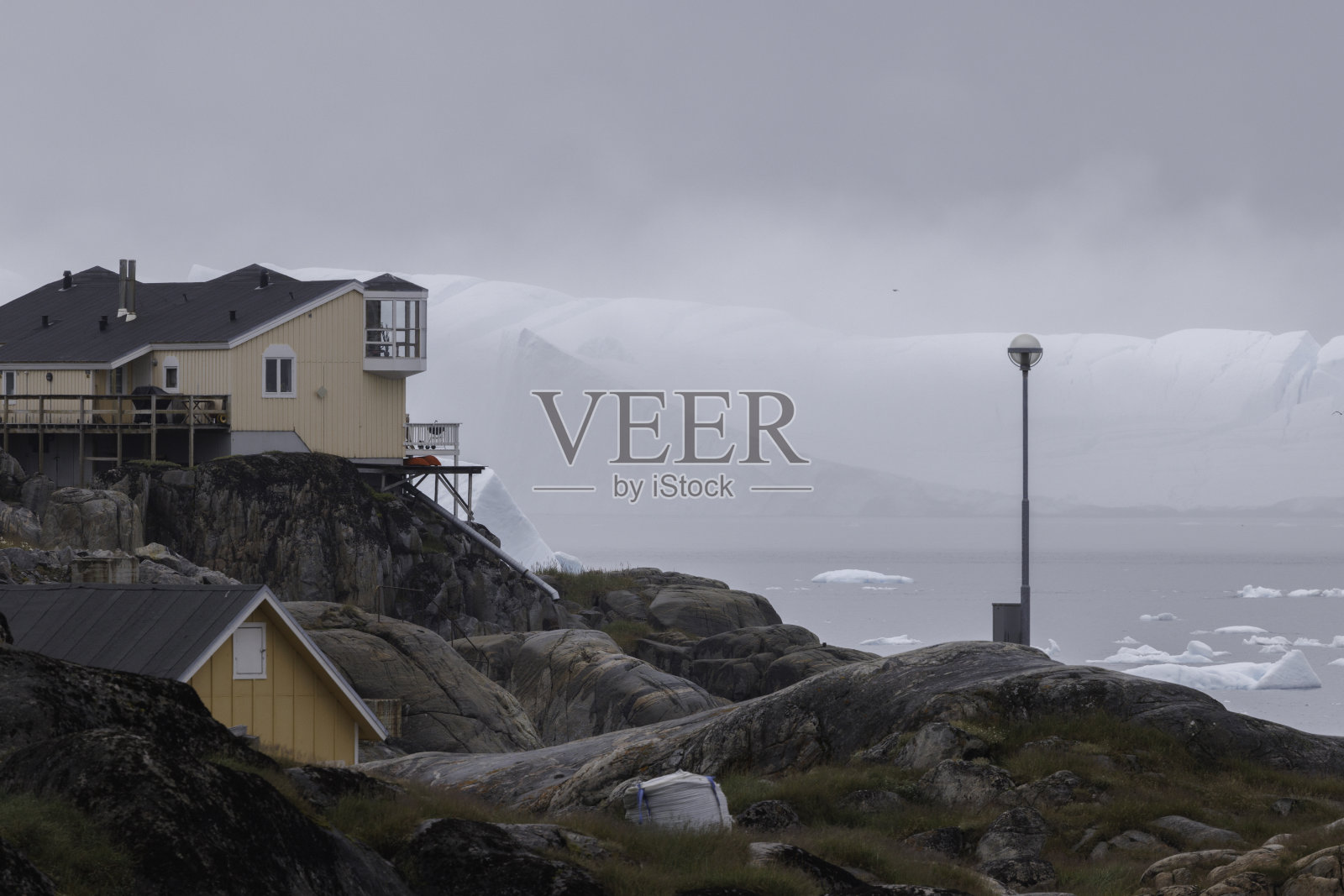 典型的带有冰山的格陵兰彩色房屋村庄。照片摄影图片