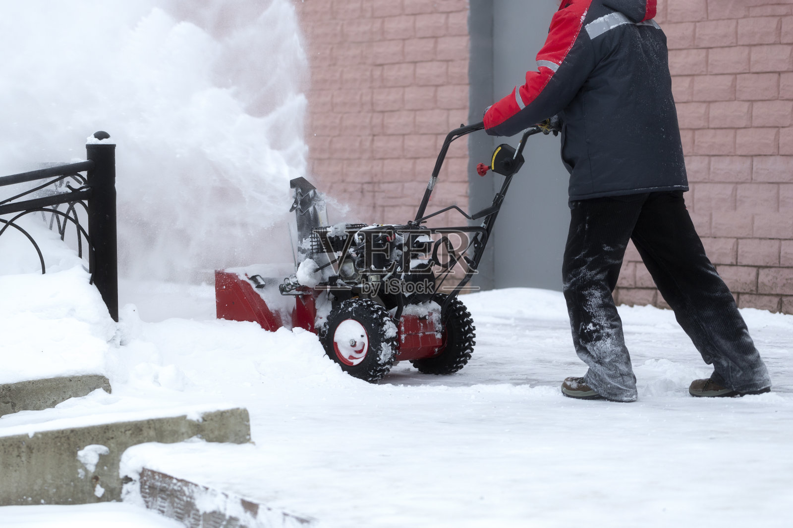 用汽油驱动的便携式吹雪机。照片摄影图片