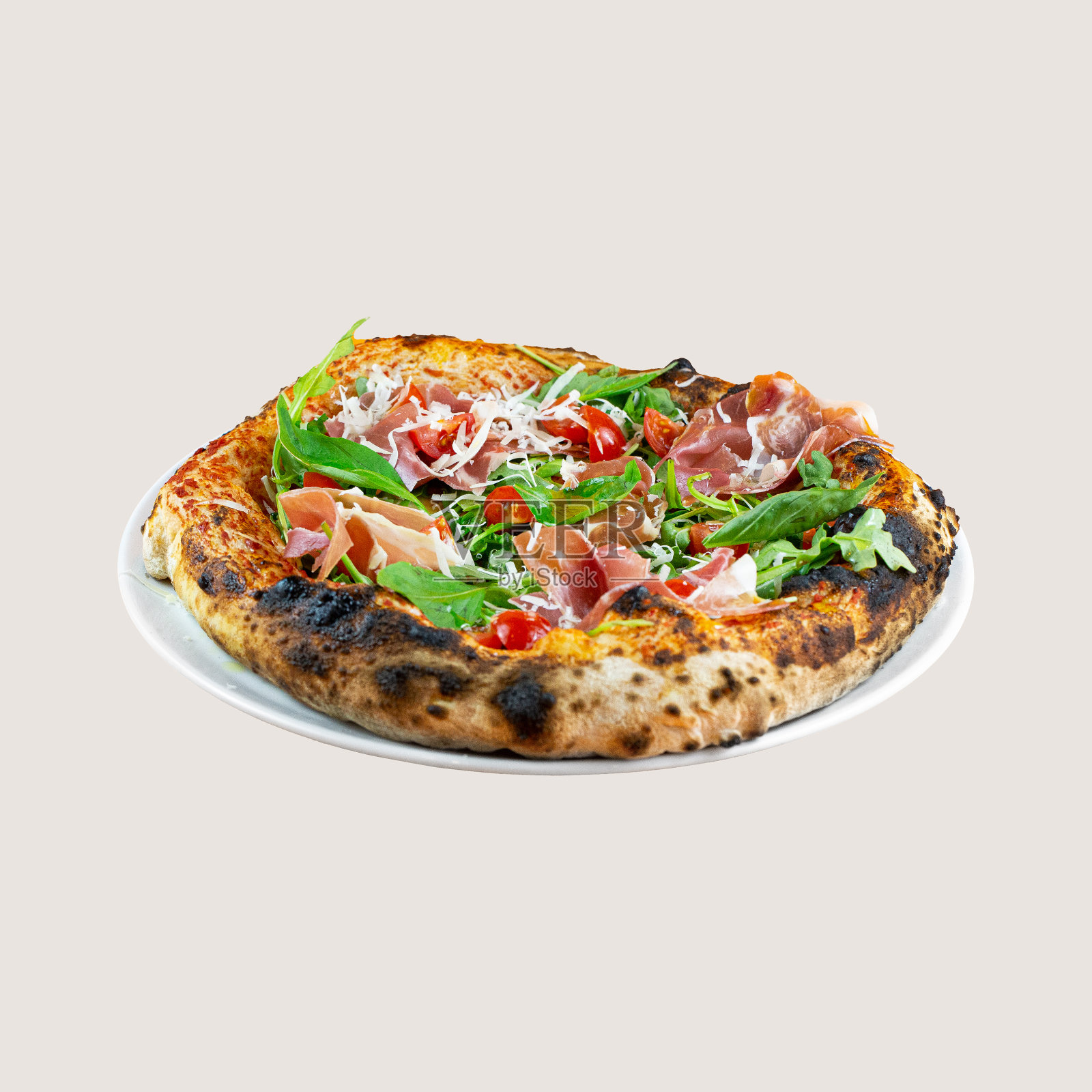 白色背景下的披萨照片。意大利的,美味的披萨。披萨配帕尔玛火腿,芝麻菜和帕尔玛干酪。那不勒斯风格的披萨照片摄影图片