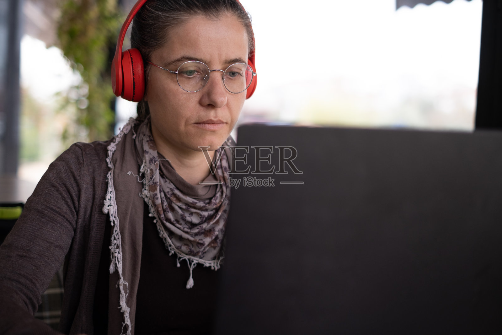 戴耳机使用笔记本电脑照片摄影图片