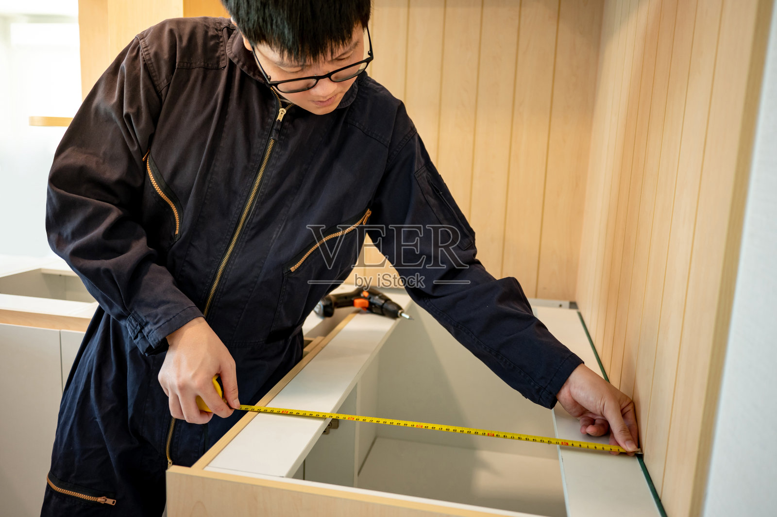 亚洲男性家具组装使用卷尺照片摄影图片