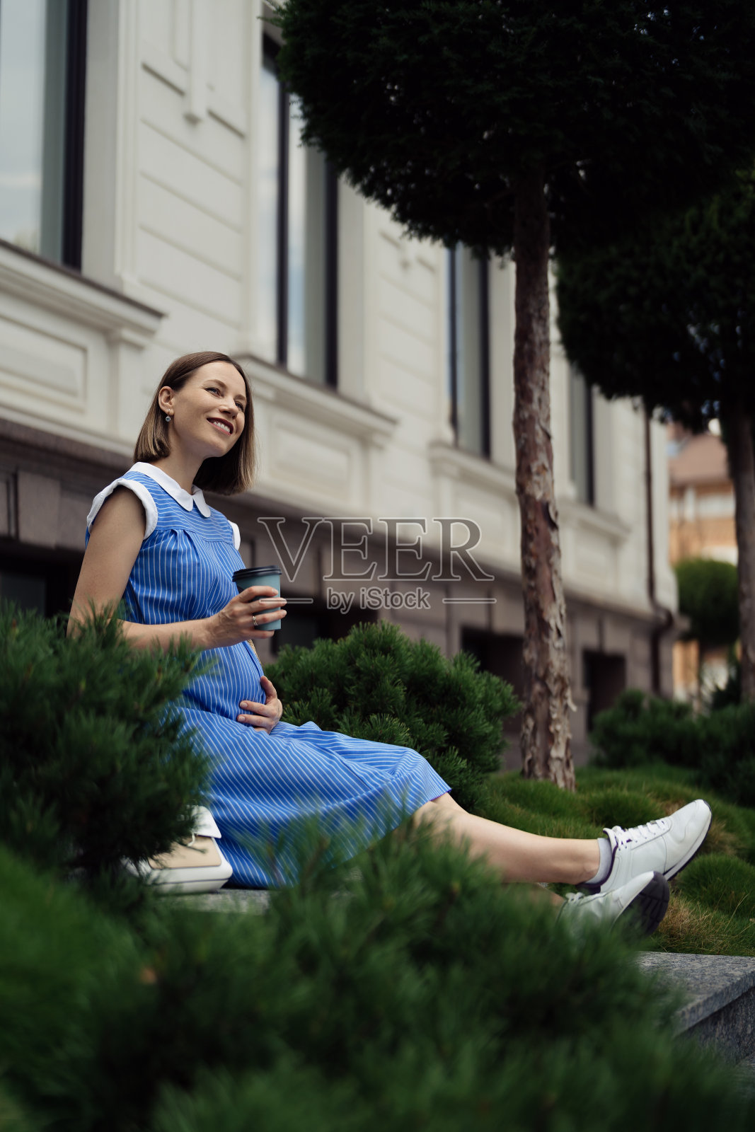 孕妇坐着休息时摸肚子照片摄影图片