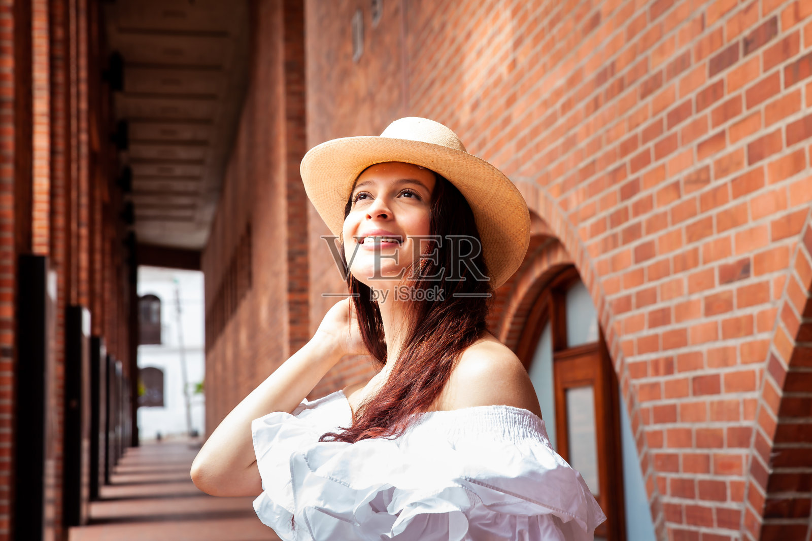 美丽的年轻女子戴着一顶传统的帽子,这顶帽子是哥伦比亚阿瓜达斯小城的典型代表,被称为阿瓜德尼奥帽。照片摄影图片