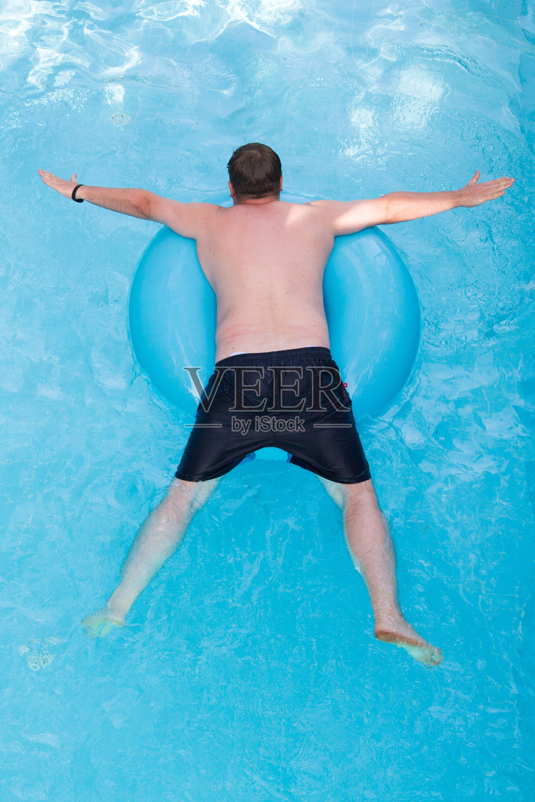 一个人漂浮在一个充气圈上,俯视图照片摄影图片