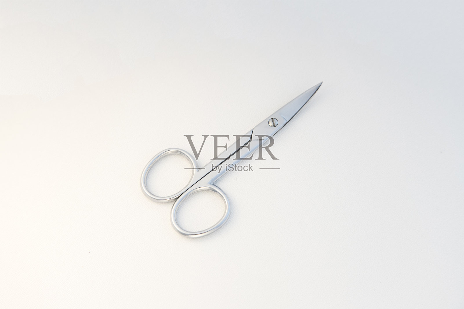 剪刀有弯曲的刀头和狭窄而尖锐的尖端孤立在白色背景上。照片摄影图片