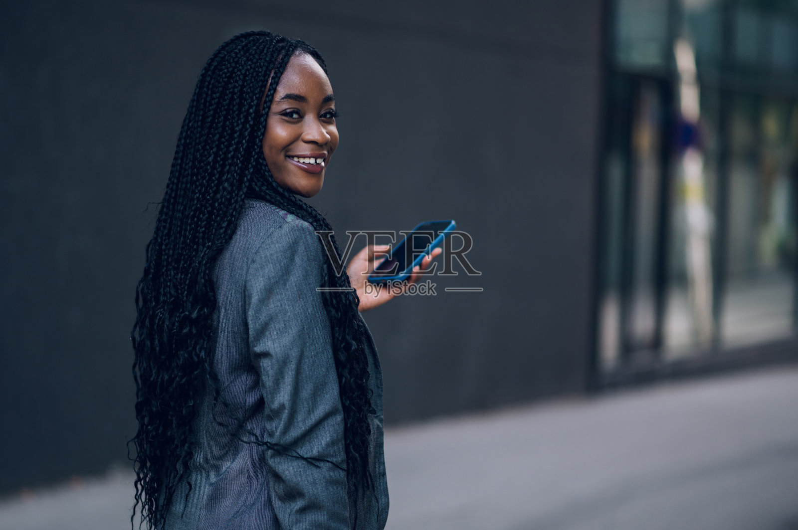 非裔美国女商人在办公楼外使用智能手机照片摄影图片