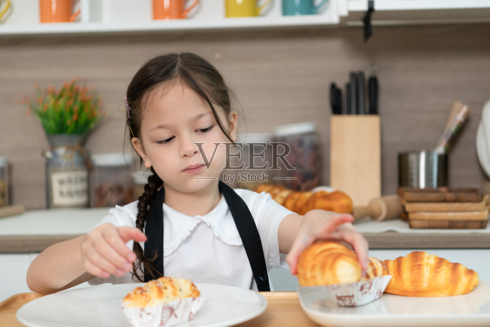一个小女孩的肖像在一所房子的厨房玩烤面包的乐趣照片摄影图片