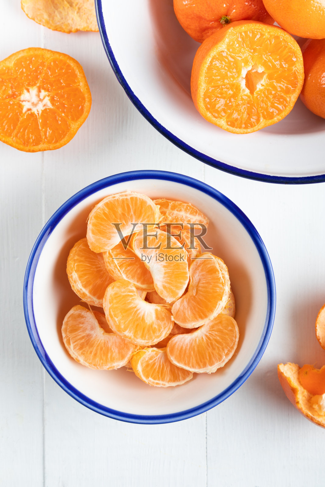 将去皮的陈皮切片放入碗中,俯视图。白色背景上的柑桔特写。照片摄影图片