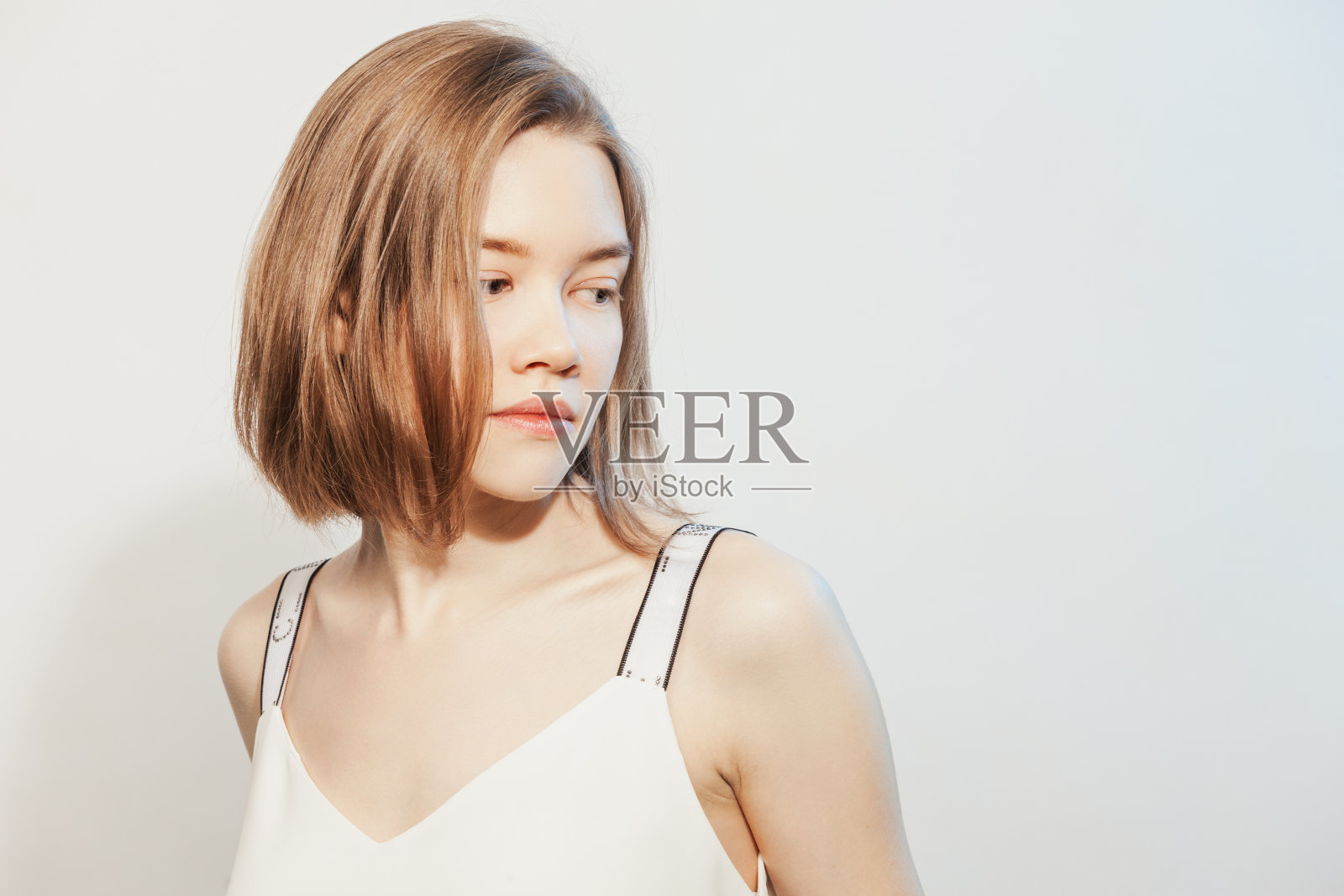 一名22岁的亚洲女性在白色背景下穿着白色背心的工作室肖像照片摄影图片