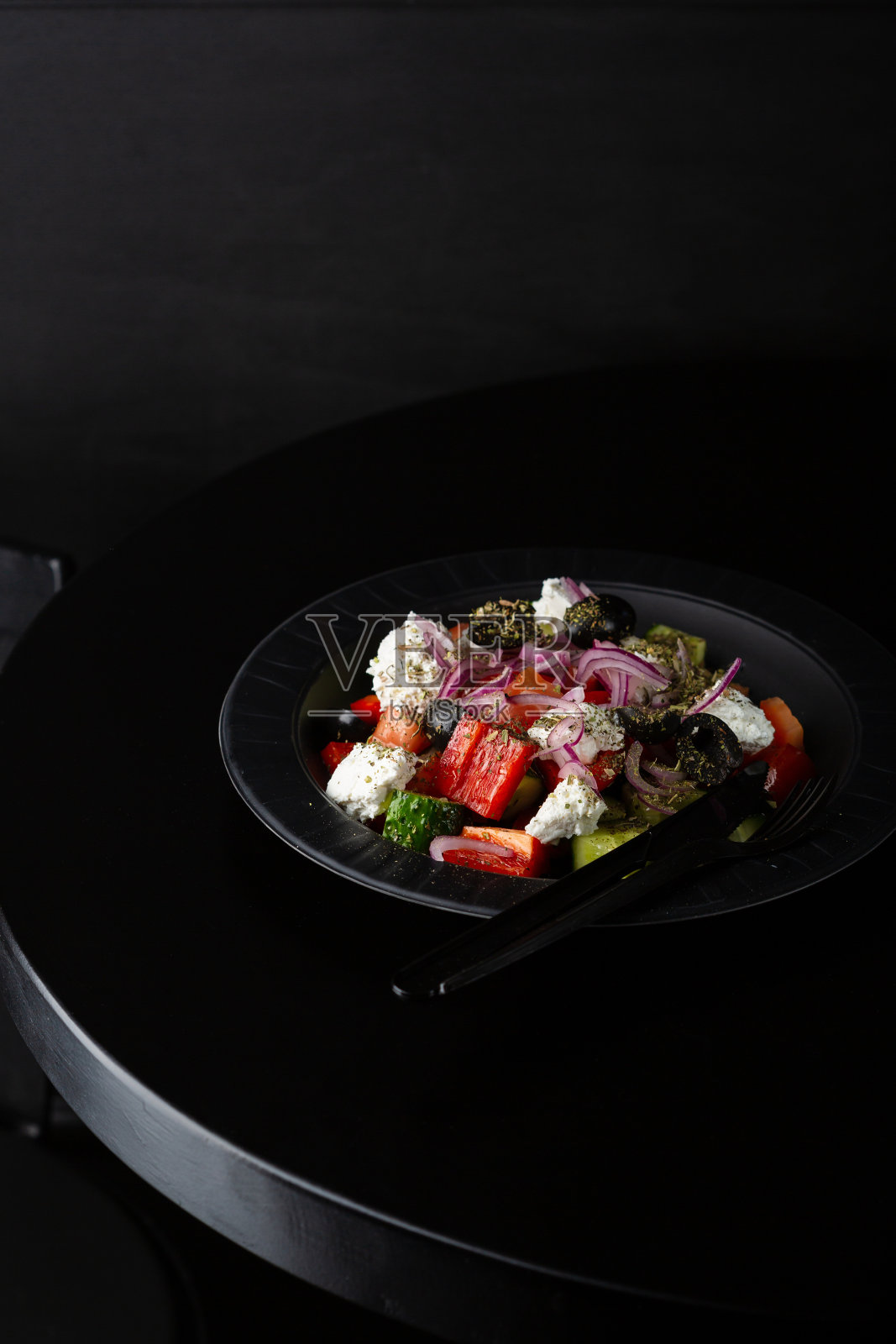 黑色餐桌上的希腊沙拉特写照片摄影图片