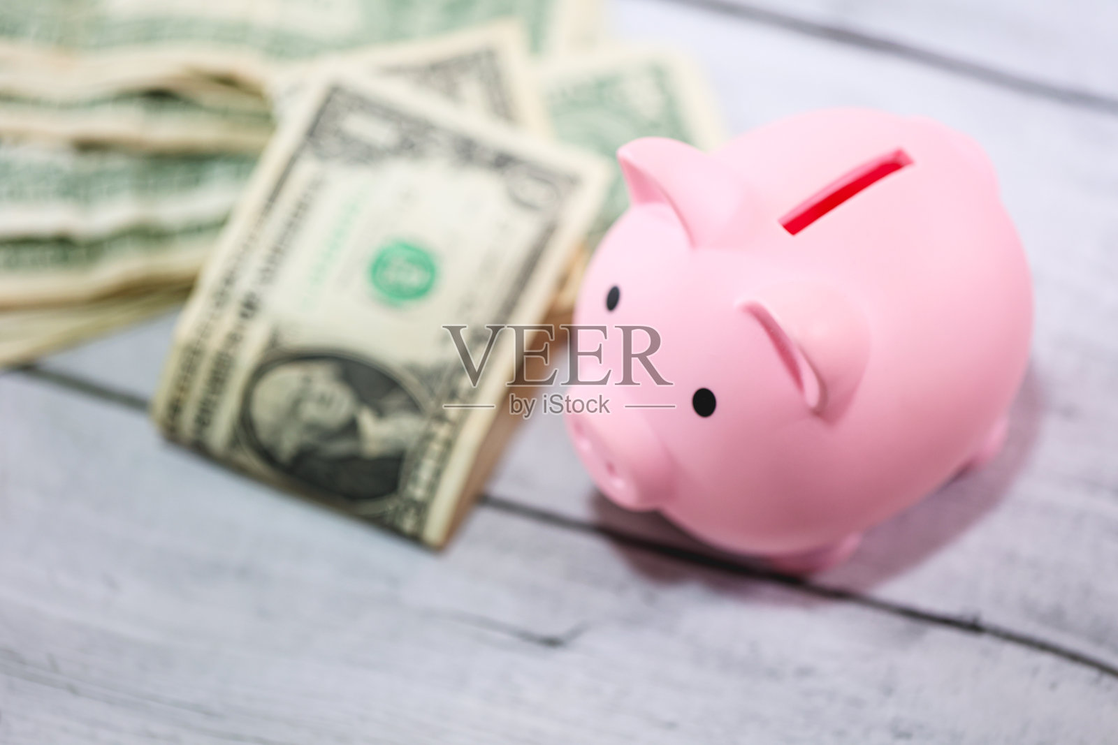 在微距摄影中,一个储蓄罐和一张木桌上的美元钞票。经济和投资。照片摄影图片