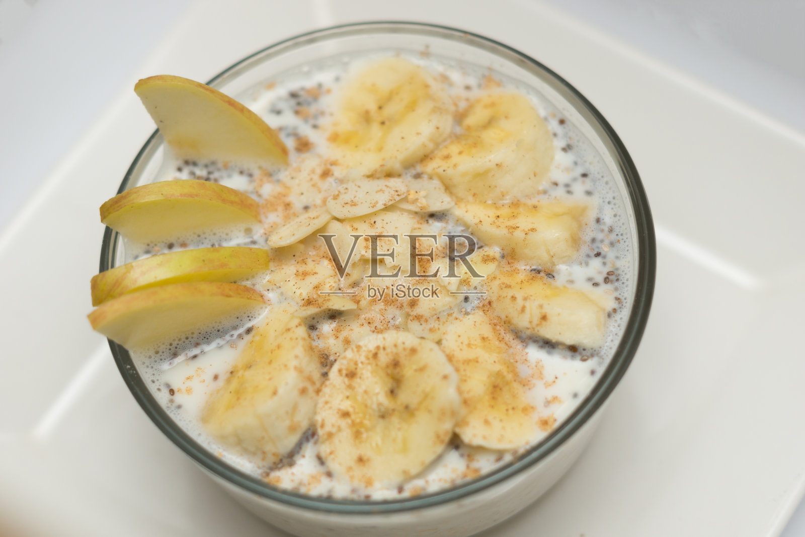 自制健康燕麦片配香蕉、苹果基亚和杏仁。燕麦粥碗。早餐的概念。营养与饮食概念照片摄影图片