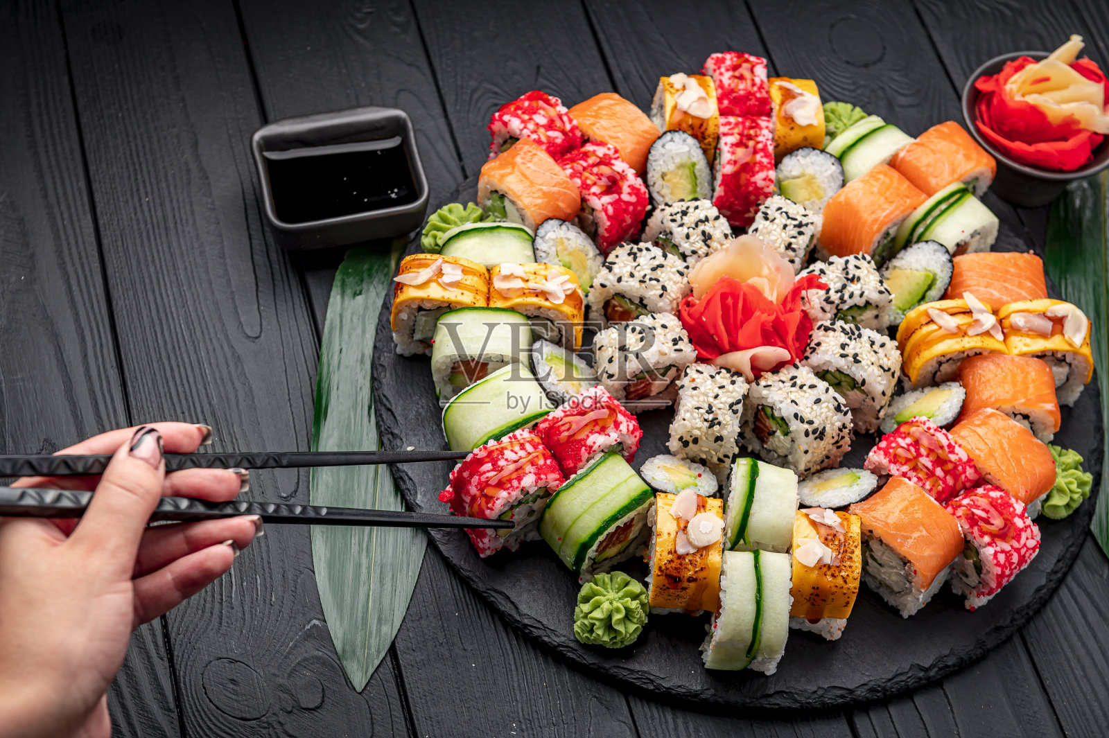 一整套亚洲食物。深色背景上的寿司和面包卷。照片摄影图片