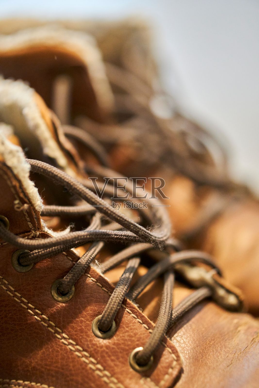 棕色靴子鞋带的垂直特写。选择的重点。照片摄影图片