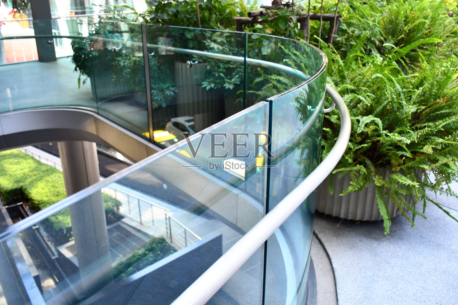 曲线钢化夹胶玻璃栏杆栏杆板框少,适用于现代建筑建筑安全玻璃。铝阳台或露台的概念设计与玻璃型材。公司和行业组合形象。照片摄影图片