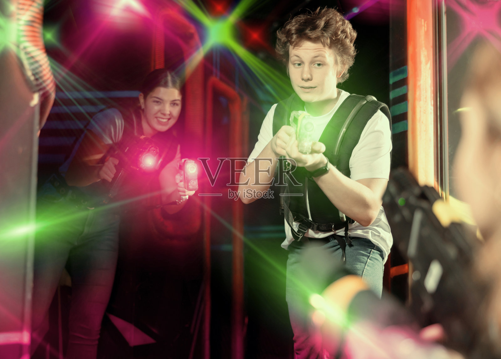 两个玩家男人和女人激光武器在黑暗的激光标签室照片摄影图片