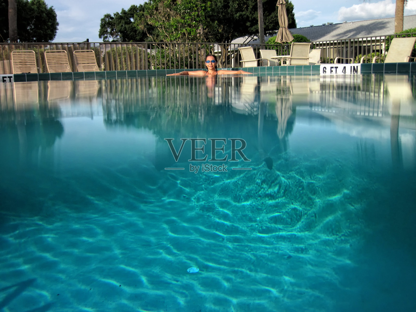 美丽的年轻女子在游泳池放松照片摄影图片