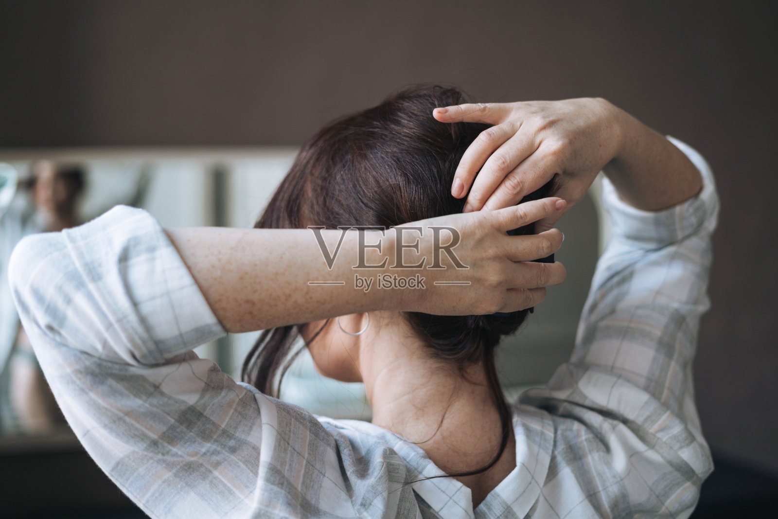 中年黑发女人把她的头发在浴室在家里照片摄影图片