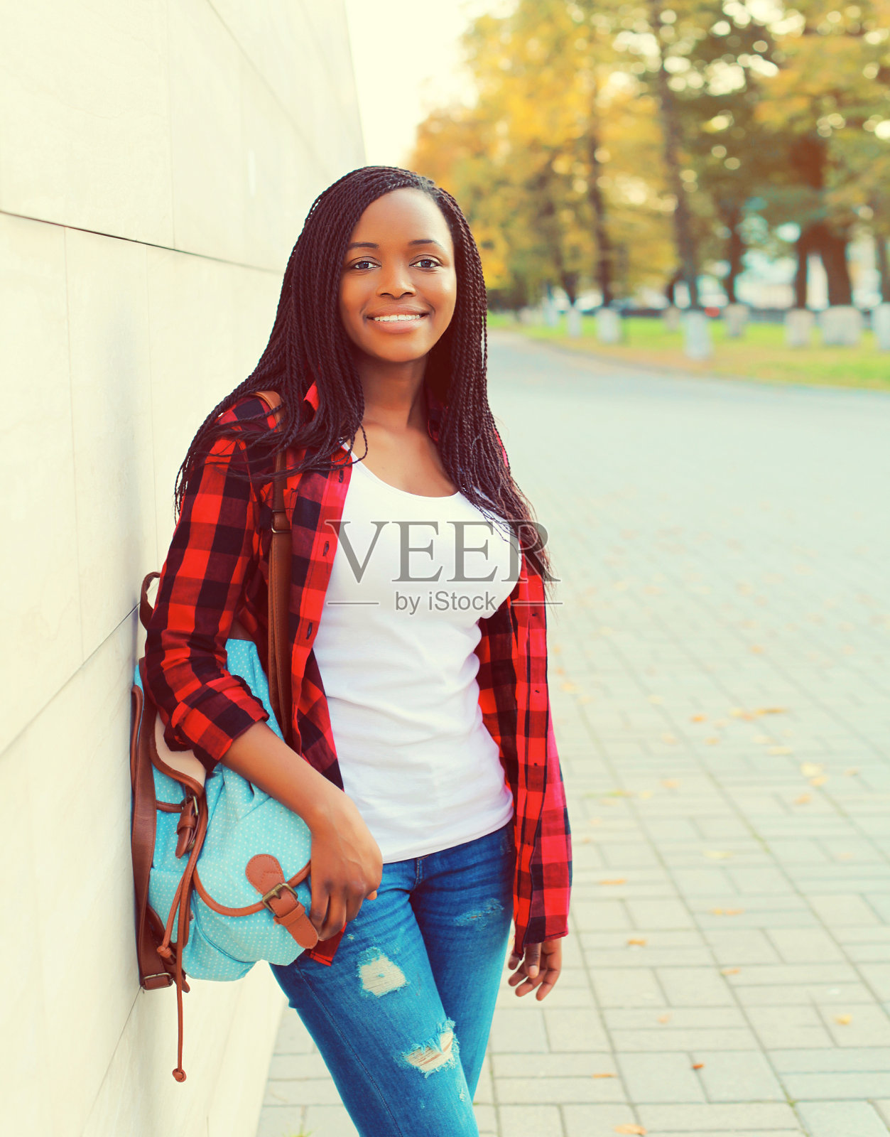 年轻的非洲妇女背着背包在城市街道上的肖像照片摄影图片