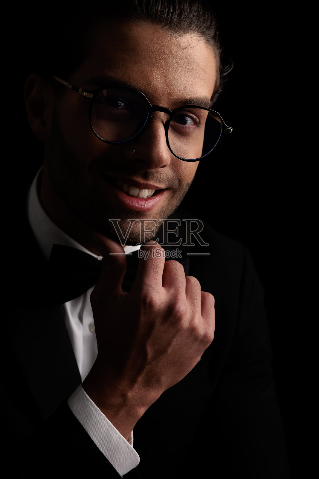 戴眼镜的快乐阿拉伯新郎触摸下巴思考和微笑照片摄影图片