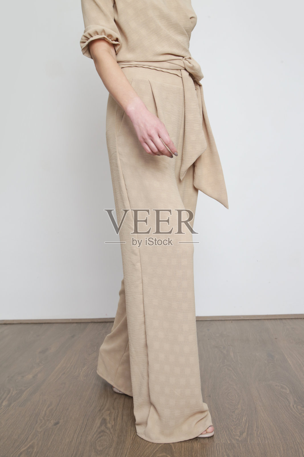 一系列的工作室照片,年轻的女模特在米色亚麻服装。照片摄影图片