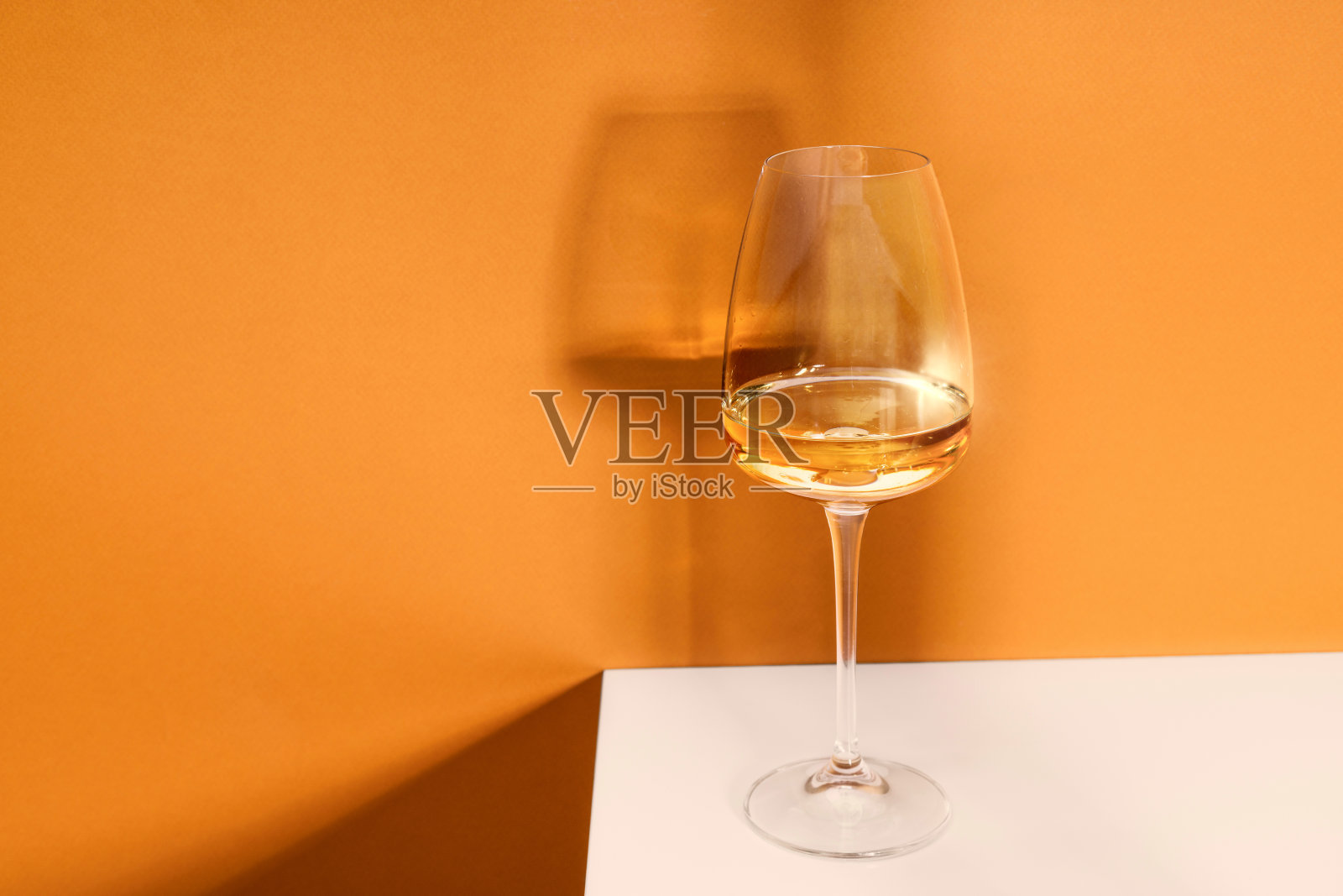 桌上有一杯白葡萄酒。光背景。照片摄影图片