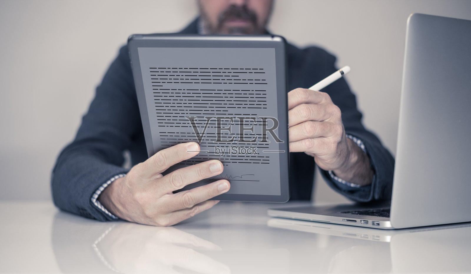 男子在平板电脑虚拟显示器上手写电子签名。签订合同、商务协议。照片摄影图片