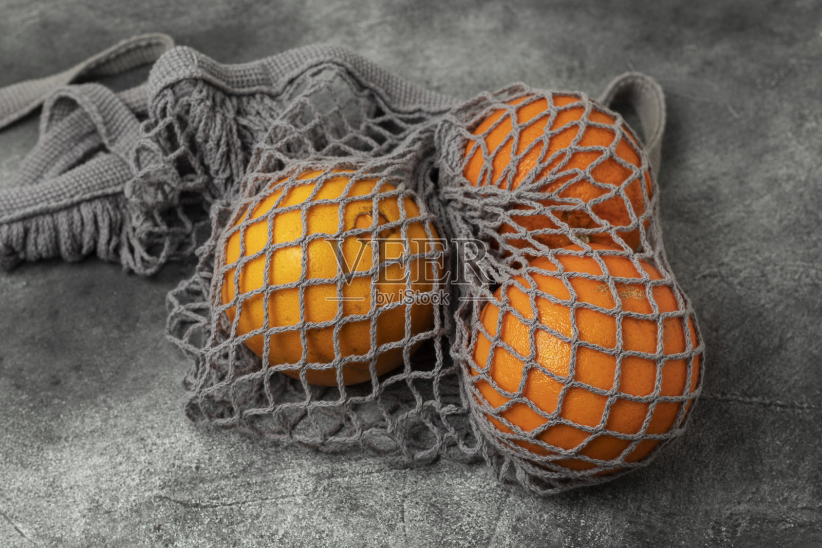 灰色网购物袋与橘子。照片摄影图片
