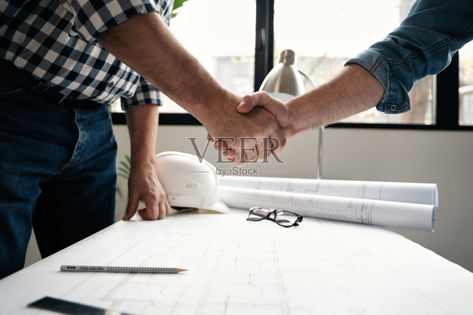 建筑师和工程师在完成一笔交易后,在工作中相互握手,以表达团队合作的理念照片摄影图片